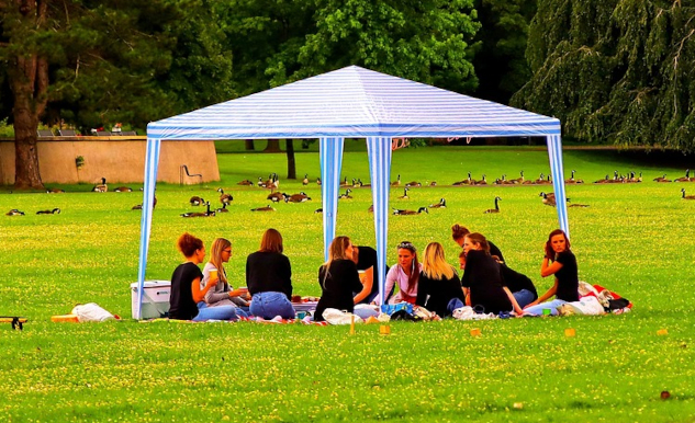 Photo of a group gathered under an outdoor canopy. Image by Thomas G. from Pixabay.&nbsp;